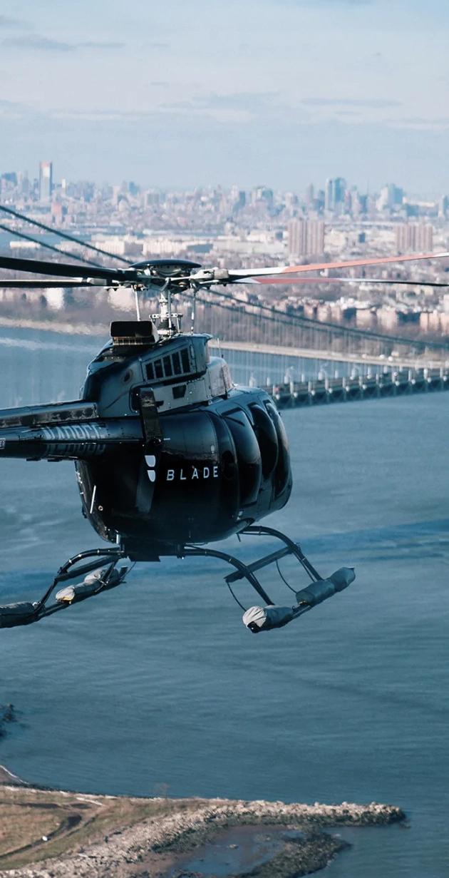 An image of a Blade helicopter flying past Verrazzano-Narrows Bridge during its usual route from JFK Airport to the Blade Heliport in Manhattan, New York City.